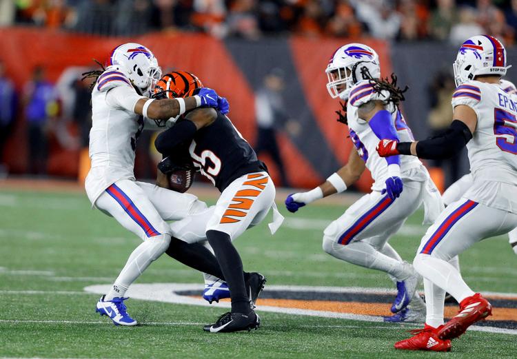 Damar Hamlin (tv.) blev ramt hårdt i bryst- og skulderregionen af Tee Higgins i kampen mellem Buffalo Bills og Cincinnati Bengals. Efter at han kortvarigt havde rejst sig op, sank han sammen med hjertestop. Foto: Joseph Maiorana/Ritzau Scanpix