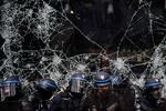 Betjente foran et ødelagt butiksvindue i Lyon tidligere i dag.  Foto: Jeff Pachoud/Ritzau Scanpix