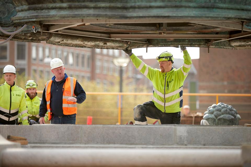 Klokken 9:11: Der stikker flere bolte ud på bronzebassinets underside. De skæres af med en vinkelsliber. Foto: Jens Dresling