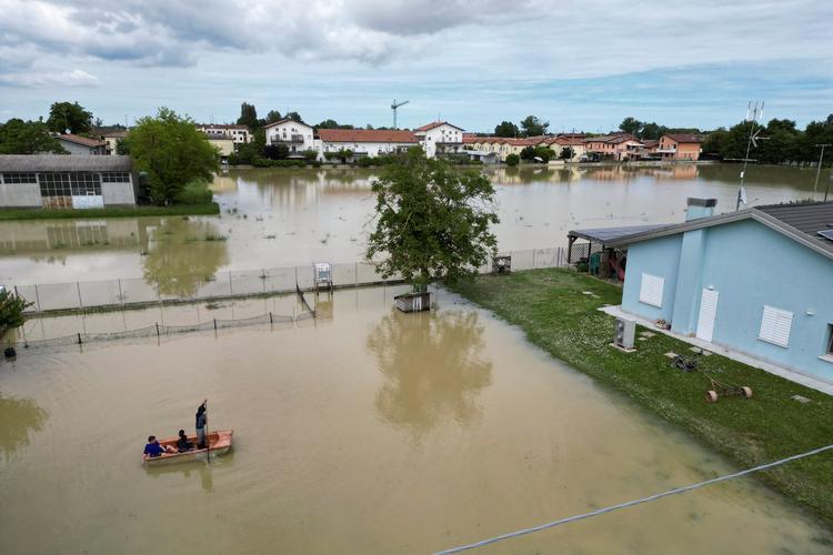     Residents use a boat to navigate through flood water after heavy rains hit Italy's Emilia Romagna region, in San Pancrazio near Ravenna, Italy, May 18, 2023. REUTERS/Antonio Denti   Foto: Antonio Denti/Ritzau Scanpix