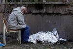 En mand sidder ved siden af sit barnebarn, der blev dræbt under russisk missilangreb. Det er uvist, om det er det barn, som ikke kunne komme ind i beskyttelsesrummet. Foto: Valentyn Ogirenko/Ritzau Scanpix