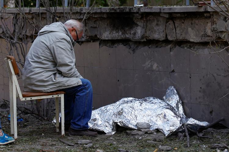 En mand sidder ved siden af sit barnebarn, der blev dræbt under russisk missilangreb. Det er uvist, om det er det barn, som ikke kunne komme ind i beskyttelsesrummet. Foto: Valentyn Ogirenko/Ritzau Scanpix
