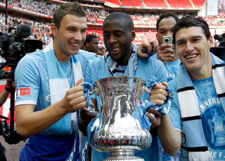 Yaya Touré har været en af de vigtigste spillere på Manchester Citys rejse fra middelmådighed til fodboldens tinder - her nyder han FA Cup-sejren i 2011 med Edin Dzeko (tv.) og Gareth Barry (th.). Men lækkede dokumenter tyder på fusk med betalingen til Tourés agent. Foto: Stefan Wermuth/Ritzau Scanpix