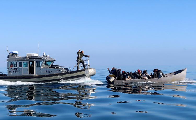 Den tunesiske kystvagt forsøger her at standse migranter med kurs mod Italien i april.  Foto: Jihed Abidellaoui/Ritzau Scanpix