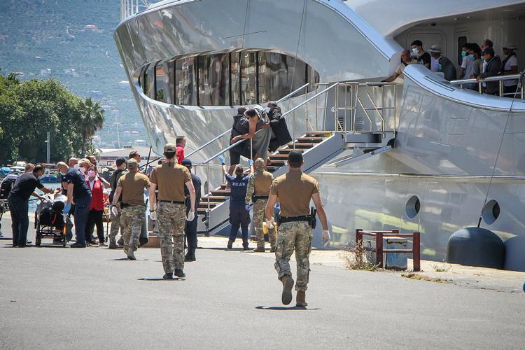 En migrant bliver båret i land i havnen i Kalamata, hvor luksusyachten lagde til. Foto: Eurokinissi/Ritzau Scanpix