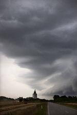 Et vejrskifte ventes at give uvejr med skybrud og torden flere steder i landet mandag. Her er vi i sommeren 2021, hvor en spektakulær skyformation er trukket ind over Bøvling Kirke i Vestjylland. Foto: Thomas Borberg