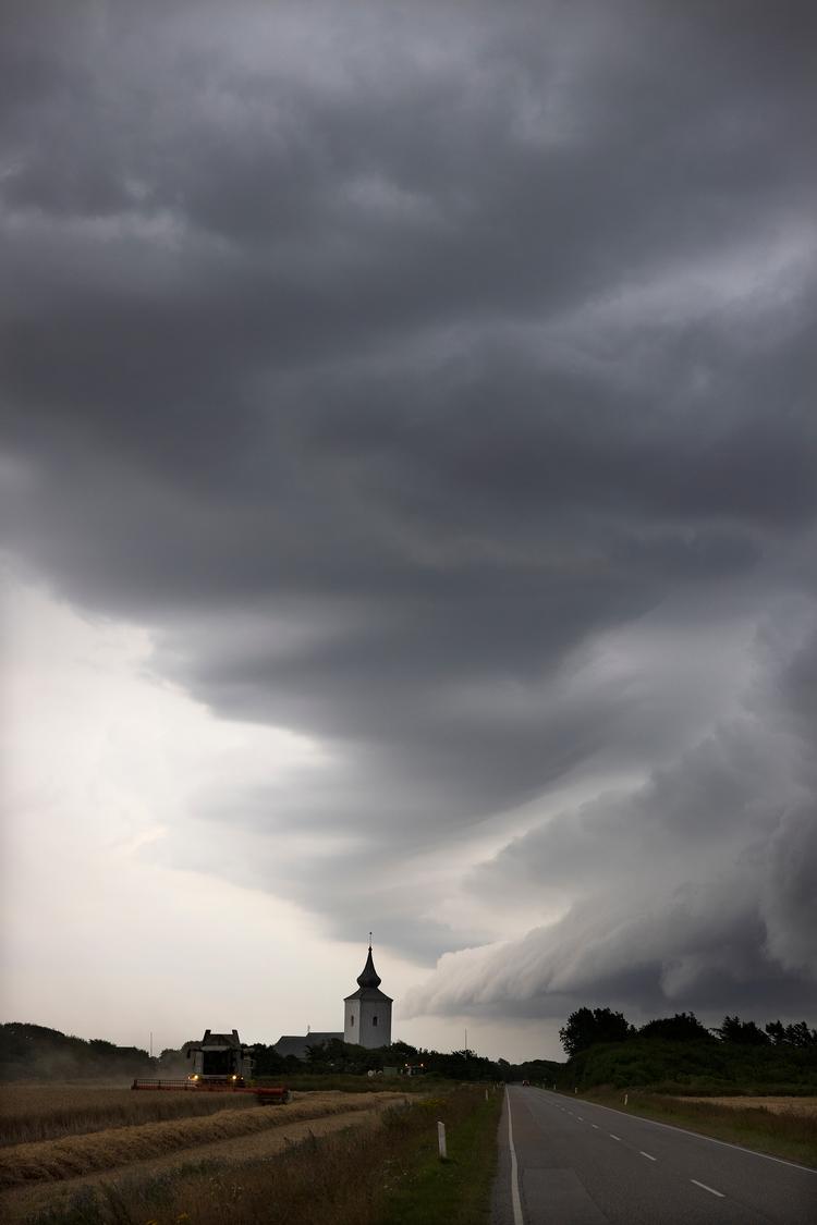 Et vejrskifte ventes at give uvejr med skybrud og torden flere steder i landet mandag. Her er vi i sommeren 2021, hvor en spektakulær skyformation er trukket ind over Bøvling Kirke i Vestjylland. Foto: Thomas Borberg