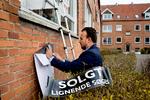 Ejendomsmægler Martin Porsmose sætter 'solgt'-skilt på en lejlighed i Brønshøj.   Foto: Finn Frandsen