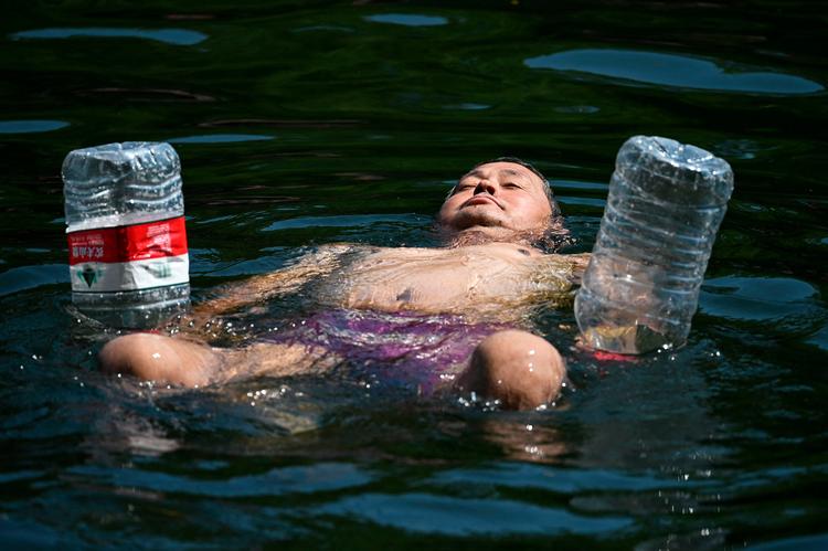De sidste dage har temperaturen i Beijing oversteget 40 grader. Mange lokale hopper i Beijings kanaler for at køle ned. Foto: Greg Baker/Ritzau Scanpix
