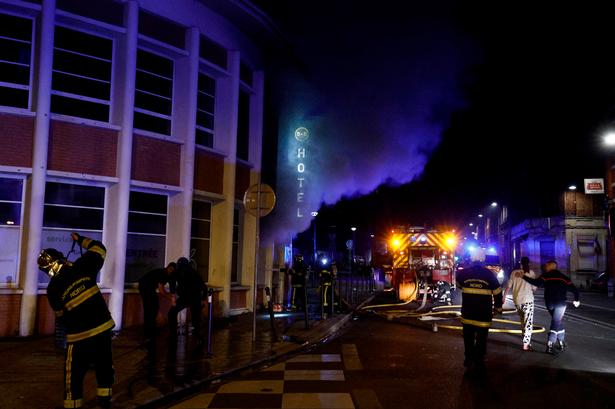     Firefighters walk with equipment after extinguishing a hotel fire during protests in Roubaix, northern France, on June 30, 2023, three days after a teenager was shot dead during a traffic stop in the Paris suburb of Nanterre. Protests over the fatal police shooting of a teenager rocked France for a third straight night on June 29, with cars burned, buildings vandalised and hundreds arrested in cities across the country. The nighttime unrest followed a march earlier on Thursday in memory of the 17-year-old, named Nahel, whose death has revived longstanding grievances about policing and racial profiling in France's low-income and multiethnic suburbs. (Photo by Kenzo TRIBOUILLARD / AFP)   Foto: Kenzo Tribouillard/Ritzau Scanpix