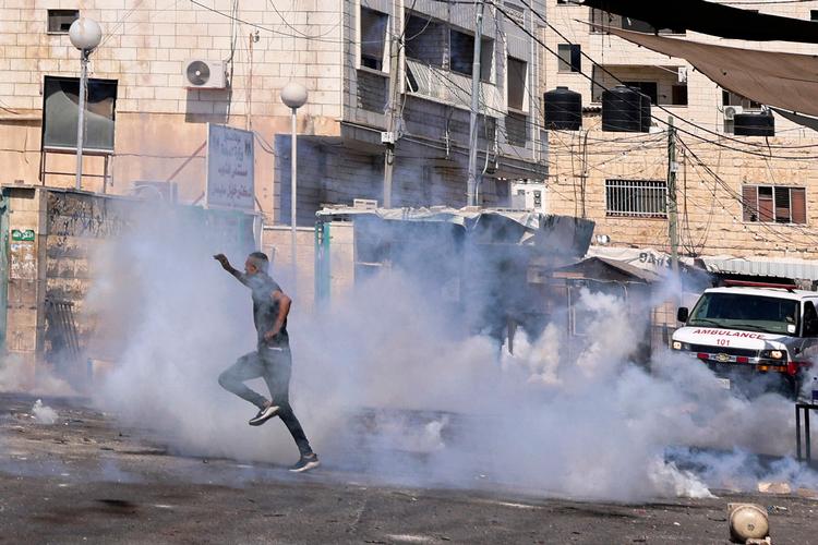 På flugt fra tåregasgranater i den palæstinensiske by Jenin, der igen er under hårdt israelsk angreb. Israel har holdt Vestbredden besat siden 1967.  Foto: Jaafar Ashtiyeh/Ritzau Scanpix