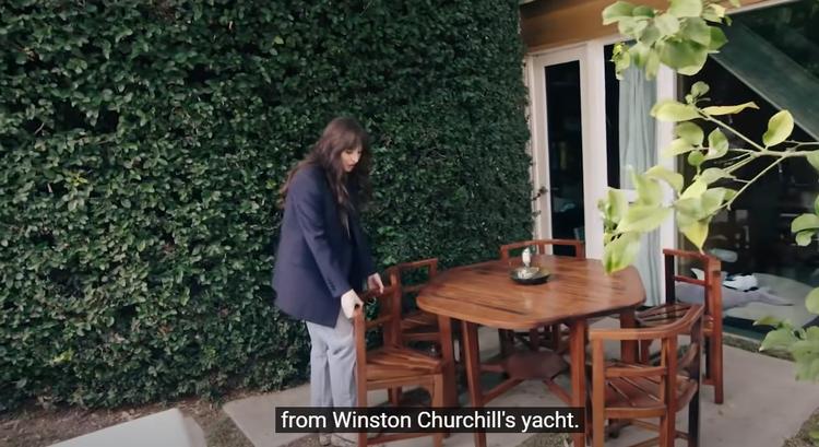 Skuespiller Dakota Johnson viser i 'Open Door'-serien rundt i sit hjem. Havemøblerne er, siger hun, lavet af træ fra Winston Churchills yacht. Og det er så cool, synes hun. Foto: Screendump fra YouTube