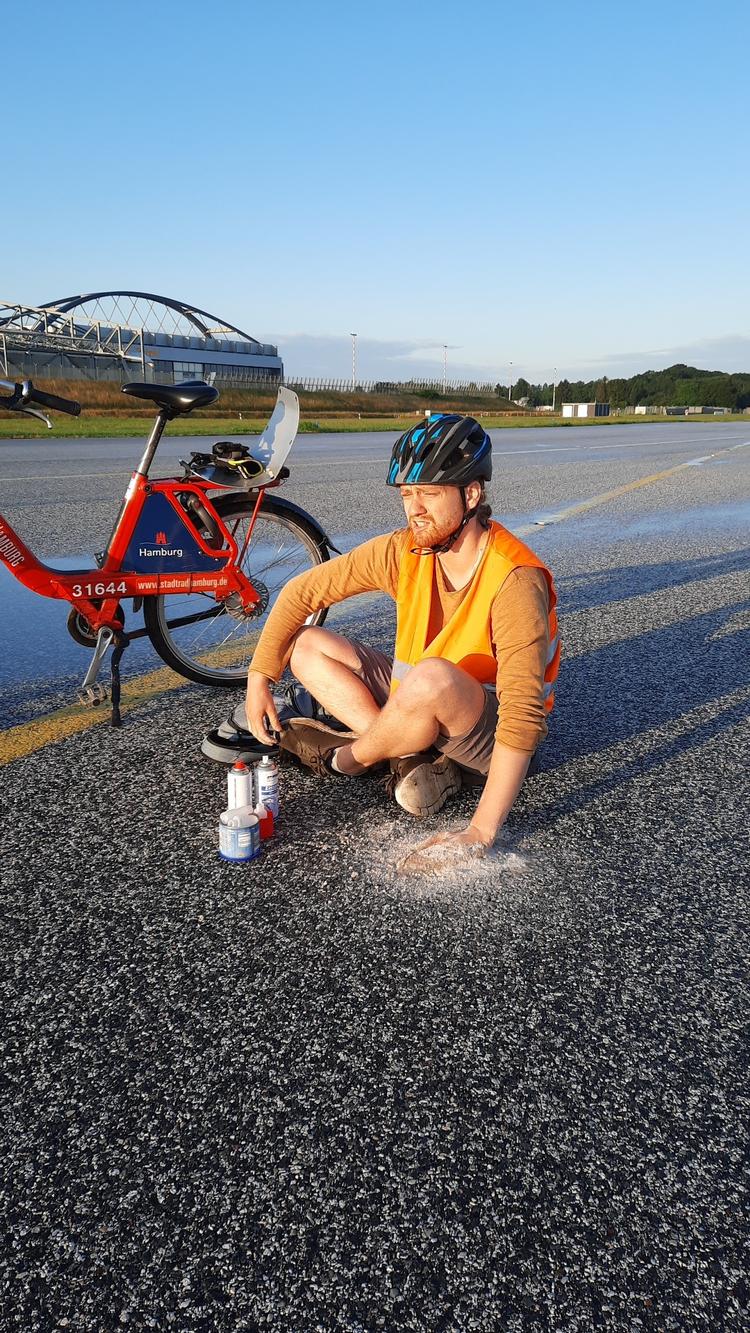 Aktivister fra klimabevægelsen Letzte Generation cyklede ind på landingsbanen i lufthavnen i Hamburg og limede deres hænder fast på asfalten. Foto: Letzte Generation