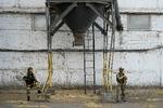 Russiske soldater bevogter en kornsilo i den besatte ukrainske by Melitopol. Over 300 af byens virksomheder er nu stjålet af russerne. Foto: Uncredited/Ritzau Scanpix