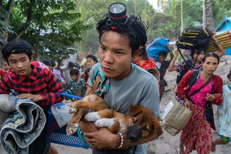 Siden militæret tog magten ved et kup i 2021, har de fordrevet halvanden million mennesker ifølge rapporter fra FN. Her er beboere fra landsbyer i Lay Kay Kaw på vej over grænsen til Thailand med deres få ejendele, herunder en hundehvalp.  Arkivfoto Jittrapon Kaicome