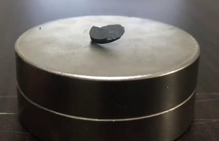 Billedet fra den koreanske artikel viser, hvordan materialet LK-99 delvist svæver over en magnet, vel at mærke ved stuetemperatur. En karakteristisk egenskaber ved superledere er, at de bliver afstødt af magnetfelter og derfor kan ses frit svævende over magneter. Ifølge de koreanske forskere skyldes det urenheder i materialet, at den kun delvist svæver. Foto: Hyun-tak Kim