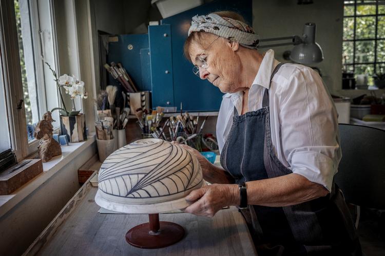 Efter at have forglødet sine krukker, begynder Beate Andersen at lægge mønstre på. Hun tegner med fri hånd, og selv om hun kan være næsten elektrisk i hovedet, inden hun begynder at tegne, oplever hun, at der falder en ro over hende.  Foto: Miriam Dalsgaard