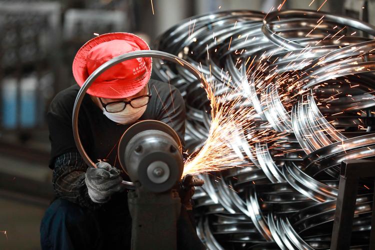 Kinas eksport er faldet 20 procent siden 2021, og afmatningen kan være med til at dæmpe den globale efterspørgsel på råverer og eneri og dermed inflationen. Her er det en ansat på en fabrik i Hangzhou, der er ved at polere cykelhjul til eksportmarkedet.  Foto: Str/Ritzau Scanpix