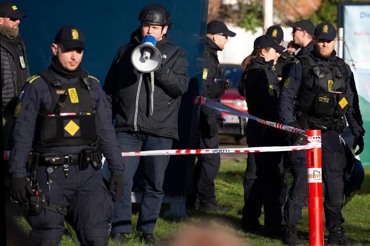     Rasmus Paludan (med megafon), 
Rasmus Paludan beskyttes af betjente under en demonstration i København, hvor han brændte et eksemplar af koranen som en symbolsk kritik af islams undertrykkelse.. Foto: Finn Frandsen
