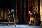 En projektør hjælper med at oplyse det meget mørke atelier, der udgør scenografien i 'Tosca'. Stefania Dovhan som Tosca lyser med den på instruktøren José Cura, der selv sang Cavaradossi ved premieren. Foto: Anders Bach