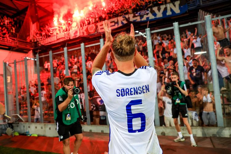 FCK's Christian Sørensen takker fansene for opbakningen, mens de kvitterer med noget af den pyroteknik, som nu udløser en straf til klubben.  Foto: Martin Divisek/epa/ritzau Scanpix/Ritzau Scanpix