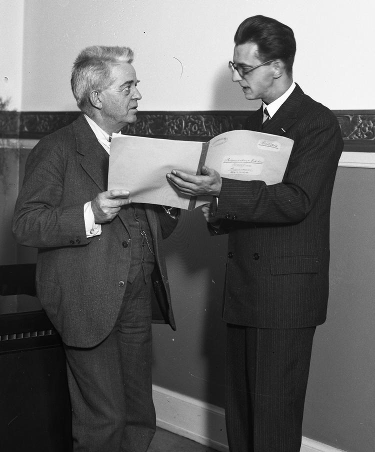 Komponisten Carl Nielsen (tv) diskuterer et partitur med en yngre mand omkring 1930.    Foto: Tage Christensen