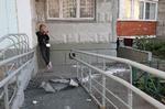 
En kvinde tjekker sin telefon ved siden af nedfalden materiale i byen Krasnogorsk, hvor en drone ifølge Rusland blev skudt ned natten til tirsdag. Foto: Stringer/Ritzau Scanpix