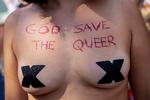En kvinde under årets Pride har 'God Save The Queer' skrevet hen over brystet. Man kunne tilføje, at Gud måske kunne bruge lidt hjælp fra vågne solidariske heteroer.  Foto: Mads Nissen