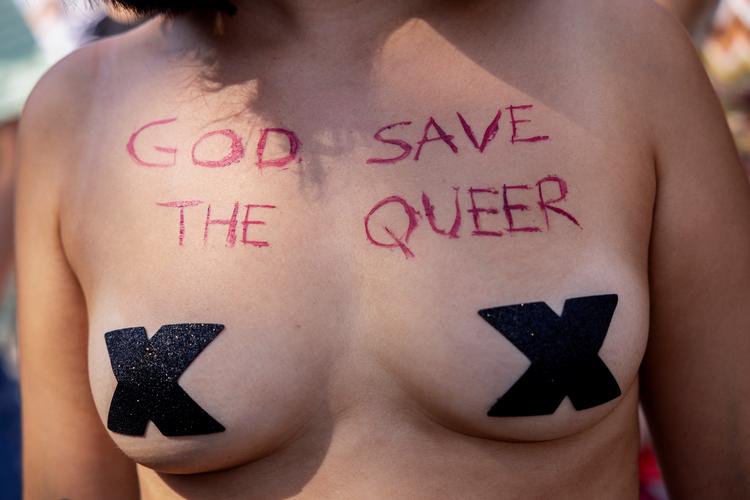 En kvinde under årets Pride har 'God Save The Queer' skrevet hen over brystet. Man kunne tilføje, at Gud måske kunne bruge lidt hjælp fra vågne solidariske heteroer.  Foto: Mads Nissen