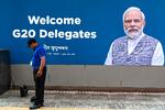 Der bliver gjort grundigt rent i New Delhi foran dette vægportræt af Narendra Modi, Indiens leder, før weekendens topmøde i G20.
 Foto: Money Sharma/Ritzau Scanpix