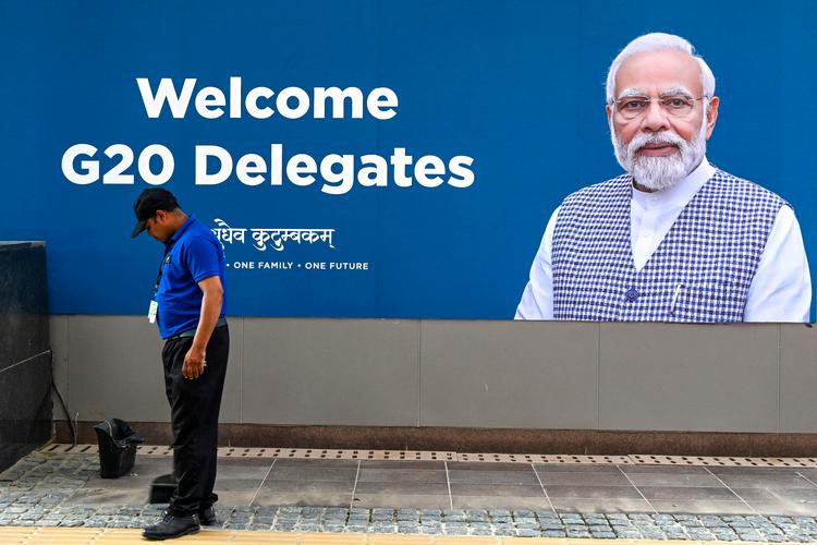 Der bliver gjort grundigt rent i New Delhi foran dette vægportræt af Narendra Modi, Indiens leder, før weekendens topmøde i G20.
 Foto: Money Sharma/Ritzau Scanpix