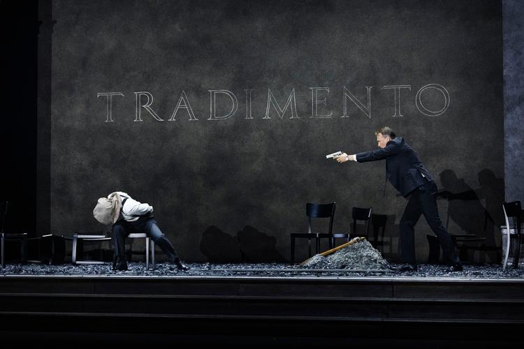 Tenoren Edgaras Montvidas i titelrollen (med pistol) og Elisabeth Jansson som forræderen Sextus er fremragende. Simple italienske gloser på bagvæggen – her ordet for forræderi – gør forestillingen let at følge med i. Foto: Miklos Szabo