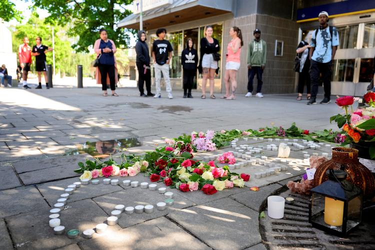 Blomster og levende lys efter et skuddrab i Farsta i det sydlige Stockholm i juni.  Foto: Tt News Agency/Ritzau Scanpix