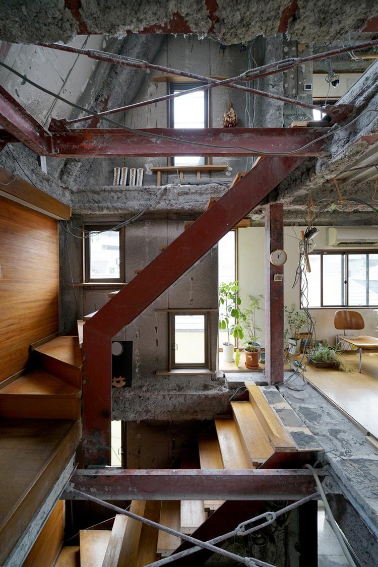 Fuminori Nousake og Mio Tsuneyama startede med at skære hul gennem etagerne rundt om trappen. For at få bedre luftcirkulation, lys og rumlig dynamik. I dag har de barn, og der er opsat værn og net.   Foto: Ryogo Utatsu