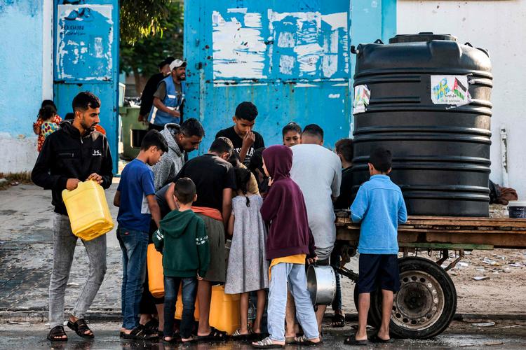 Børn henter vand fra en transportabel cisterne i det sydlige Gaza 19. oktober. Over en million indbyggere i det belejrede område er afhængige af nødhjælp, som har været blokeret. Foto: Mohammed Abed/Ritzau Scanpix