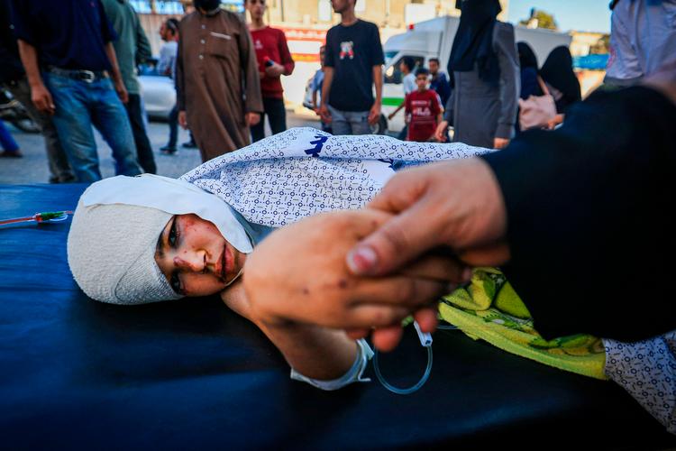  De civile i Gaza lider både under bombardementer, blokade og mangel på nødhjælp.  Her trøster en mor sit sårede barn på Nasser Hospitalet i Khan Yunis i det sydlige Gaza.  Foto: Mahmud Hams/Ritzau Scanpix