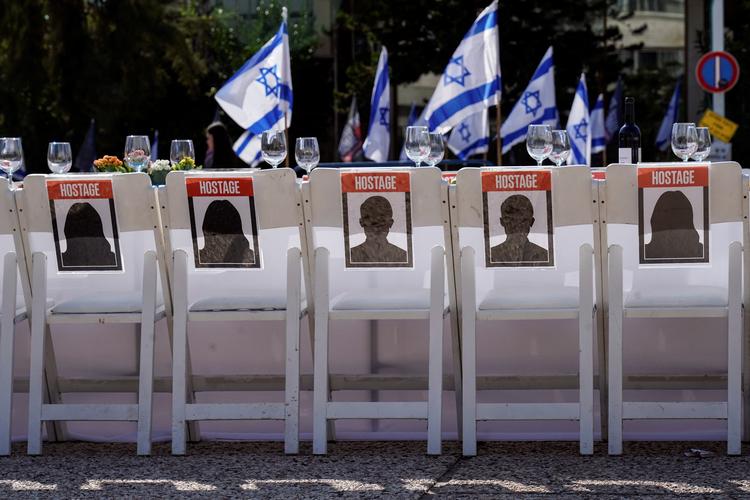I Tel Avis i Israel er et opdækket middagsbord sat op med omkring 200 tomme stole, der repræsenterer gidsler og deres familier, der venter på at få dem hjem. Foto: Janis Laizans/Ritzau Scanpix