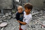 Palæstinensiske børn står foran murbrokkerne i byen Khan Younis i den sydlige del af Gazastriben.  Foto: Ibraheem Abu Mustafa/Ritzau Scanpix