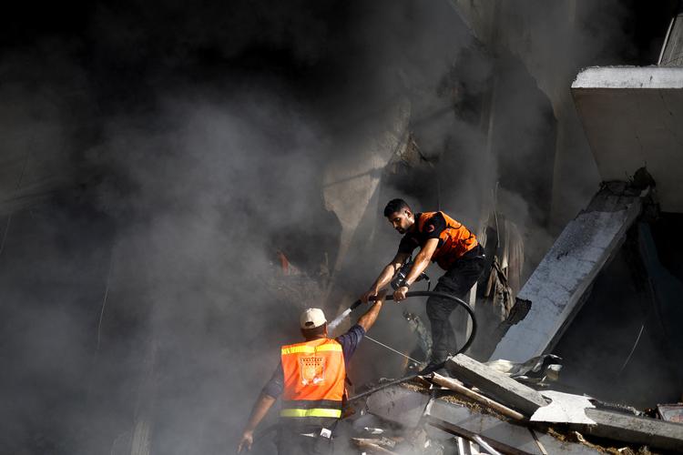 Brandmænd kæmper mod krigen og  røgen i det sydlige Gaza. Tyrkiet foreslår, at en række »garantimagter« efter krigen går ind mellem palæstinenserne og israelerne. Foto: Mohammed Salem/Ritzau Scanpix