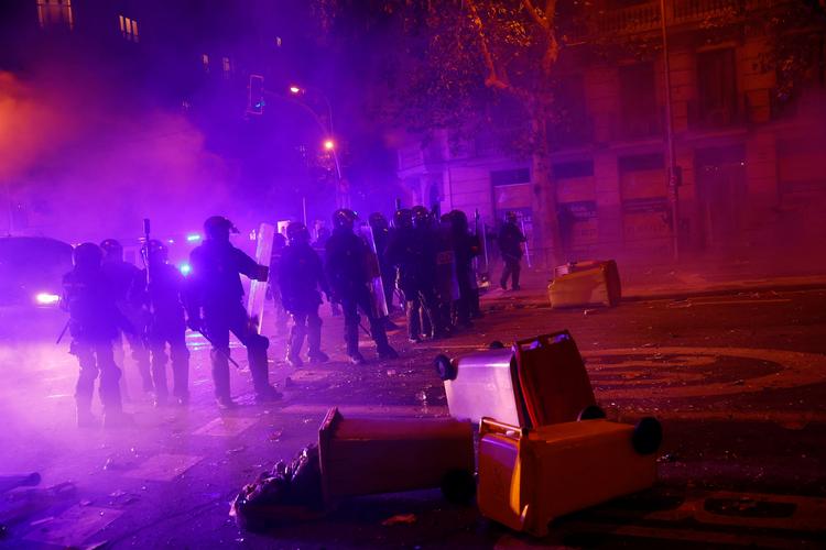 Spansk polii beskytter regeringspartiet, PSOE's, hovedkvarter i Madrid mod vrede demonstranter.  Foto: Susana Vera/Ritzau Scanpix