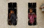 Palæstinensiske børn kigger ud vinduer i et område ramt af israelske bombardementer.  Foto: Ibraheem Abu Mustafa/Ritzau Scanpix