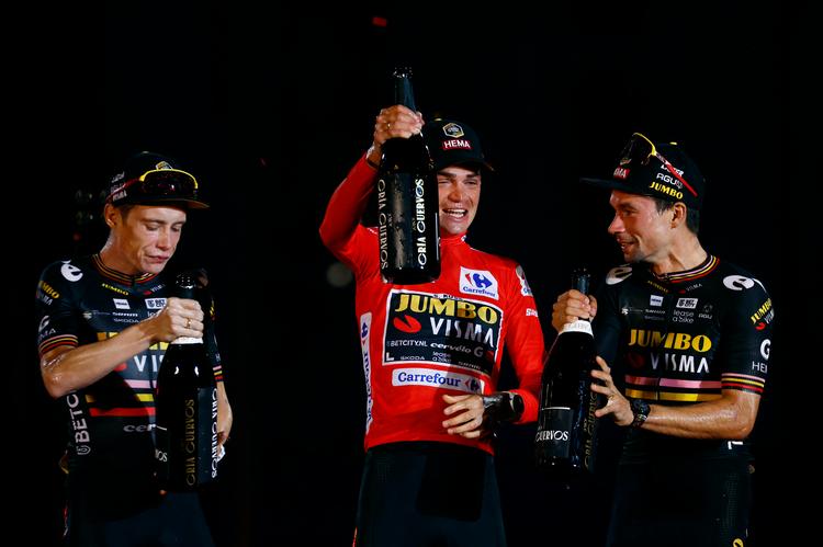 Sepp Kuss (i midten i rød) fejrer sejren i Vuelta a Espana sammen med holdkammeraterne Jonas Vingegaard (tv.) og Primoz Roglic. Foto: Susana Vera/Ritzau Scanpix