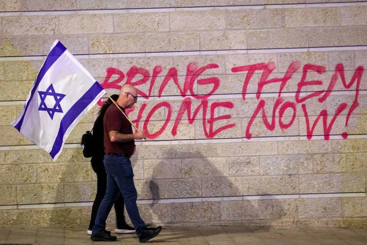'Bring de israelske gidsler hjem', står der på en mur i Jeruisalem. Kravet er blevet omdrejningspunkt for kritik af Netanyahu-regeringen. Han satser på, at deres løsladelse også kan vende folkestemningen imod hans regering. Foto: Gil Cohen-magen/Ritzau Scanpix