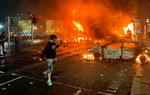 Flammerne rejser sig fra en bil og en bus i Dublins gader. Foto: Peter Murphy/Ritzau Scanpix