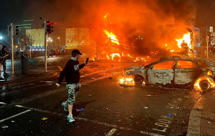 Flammerne rejser sig fra en bil og en bus i Dublins gader. Foto: Peter Murphy/Ritzau Scanpix