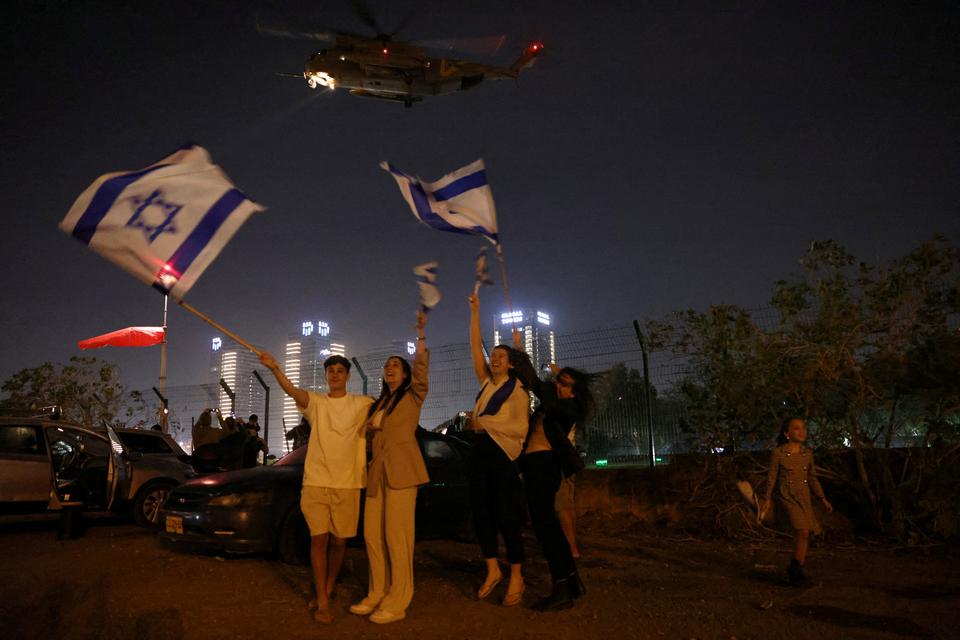 Der blev vinket med israelske flag, da en helikopter med en gruppe af de gidsler, Hamas havde frigivet, fredag lettede Schneider Children's Medical Center i Petah Tikva i Israel, et af de hospitaler, hvor gidslerne blev undersøgt efter løsladelsen.    Foto: Ronen Zvulun/Ritzau Scanpix