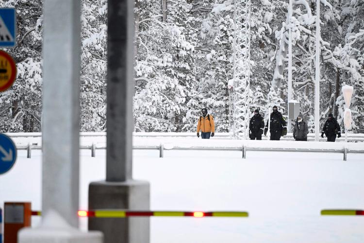 Finske grænsevagter tilbageholder to migranter ved fotograferet ved grænseovergangen i Inari i det nordlige Finland i går.  Foto: Emmi Korhonen/Ritzau Scanpix