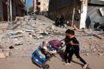 I pauserne mellem bomberegn og ildkampe søger de børn og voksne der tror på de israelske sikkerhedszoner efter et ly for krigen.    Foto: Mohammed Abed/Ritzau Scanpix