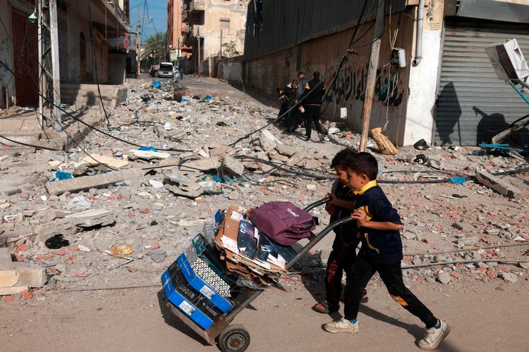 I pauserne mellem bomberegn og ildkampe søger de børn og voksne der tror på de israelske sikkerhedszoner efter et ly for krigen.    Foto: Mohammed Abed/Ritzau Scanpix