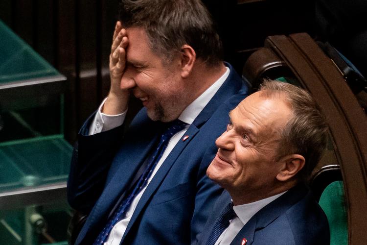 Donald Tusk lytter her til sin forgænger Mateusz Morawickis tale mandag formiddag, inden parlamentet stemte PiS-regeringen ned og senere stemte for Tusk som ny statsminister.  Foto: Wojtek Radwanski/Ritzau Scanpix